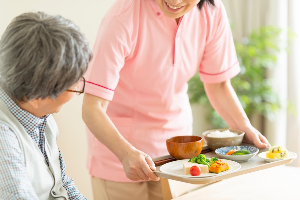 スタッフがご利用者様に食事を配膳する様子