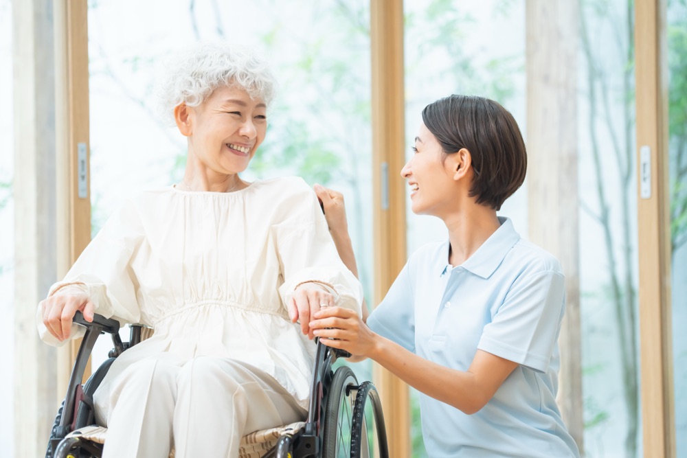 窓辺でスタッフとご利用者様が穏やかに過ごす様子